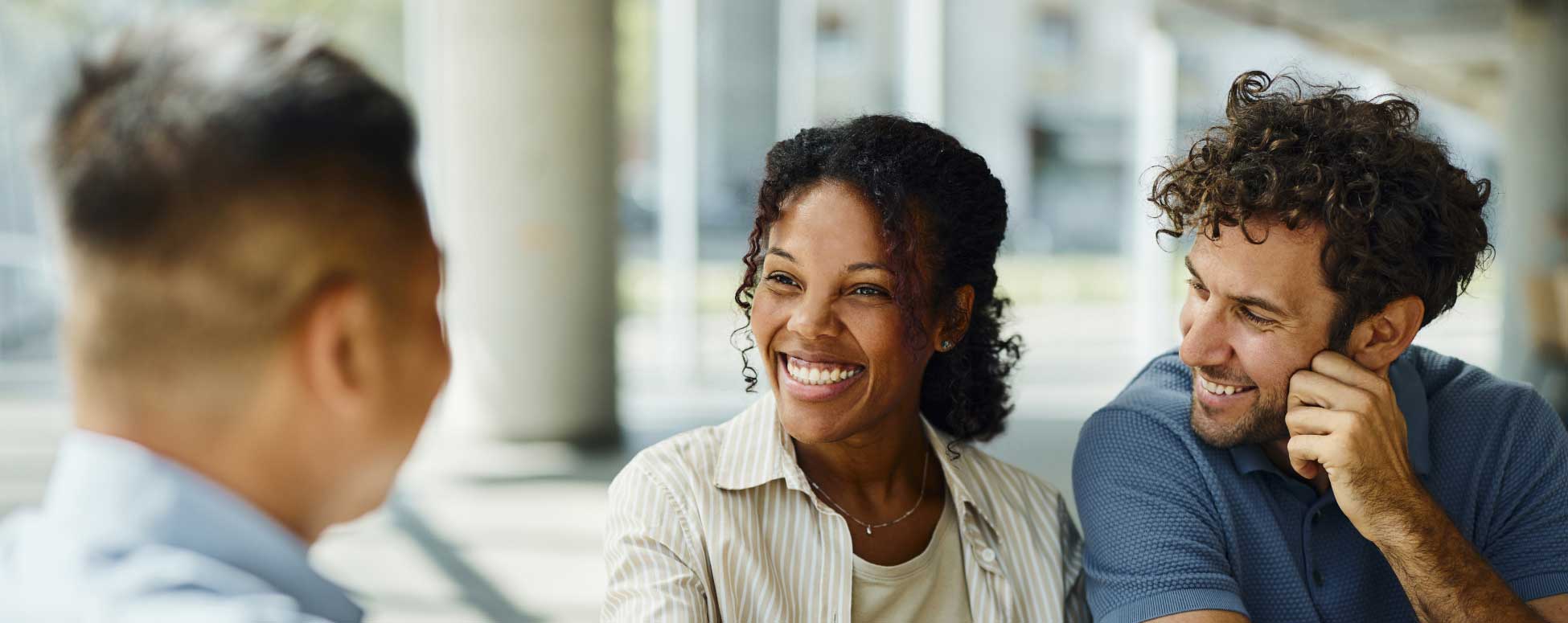 Young couple inside a bank meeting with a financial coach.