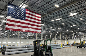 Interior of a large warehouse with an American flag hanging overhead.