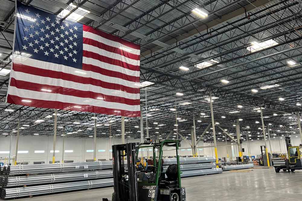 Interior of a warehouse with a large American flag hanging overhead.