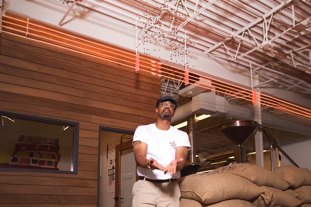 Man thowing coffee beans into the air.