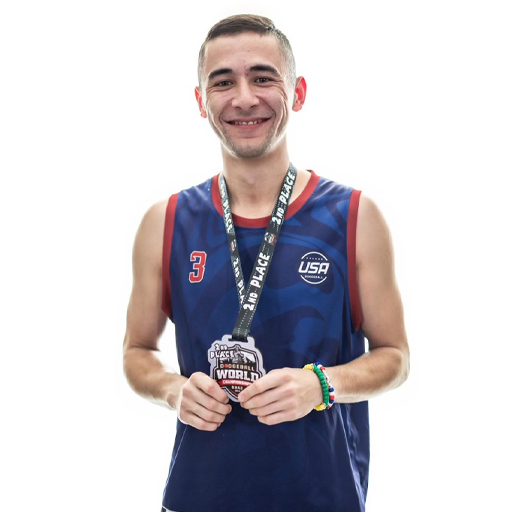 Man wearing athletic uniform with silver medal around his neck