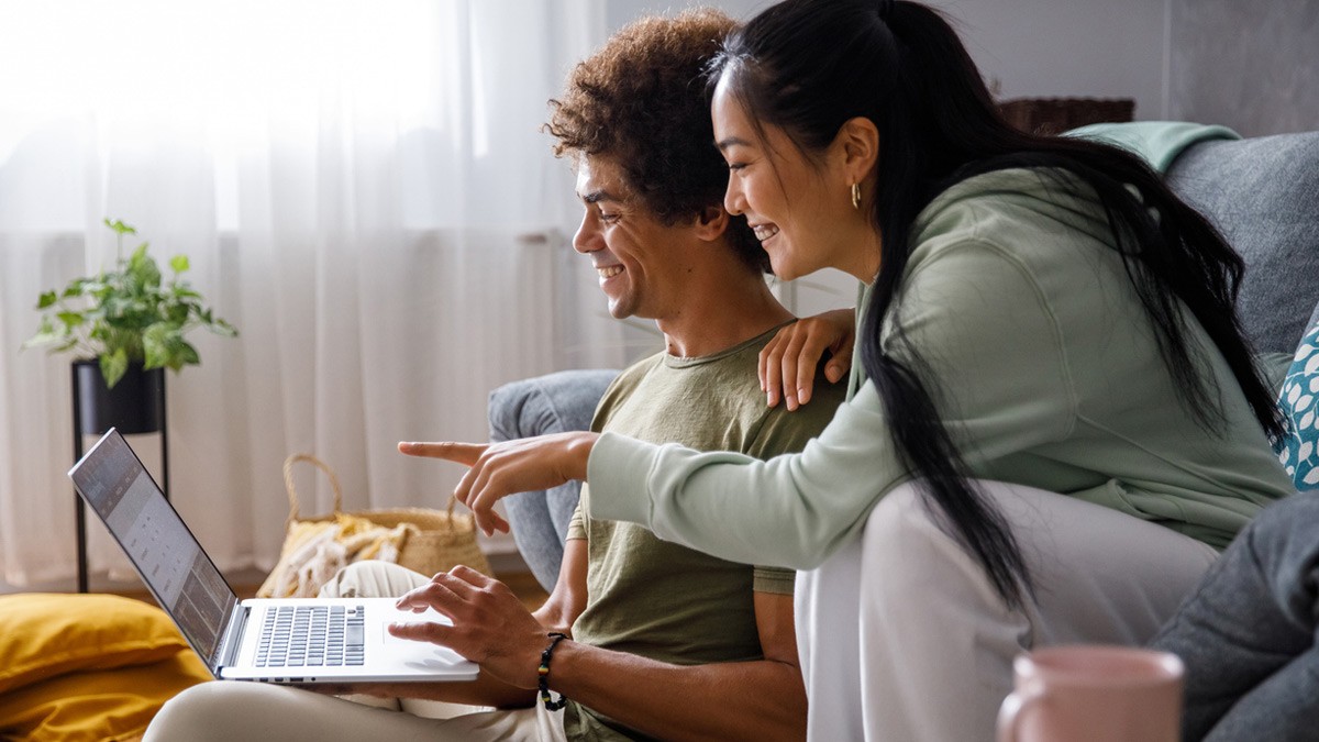 Couple smiling at a laptop computer