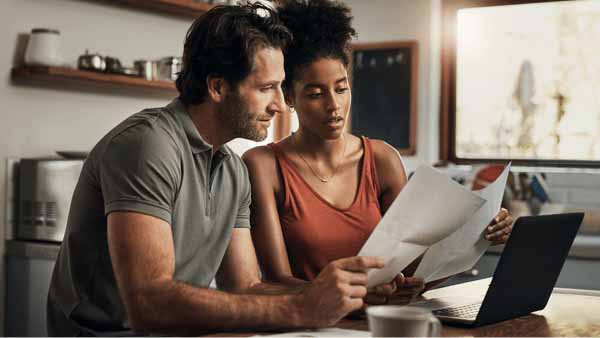 A Couple reviewing budget paperwork to plan for a down payment on a new home