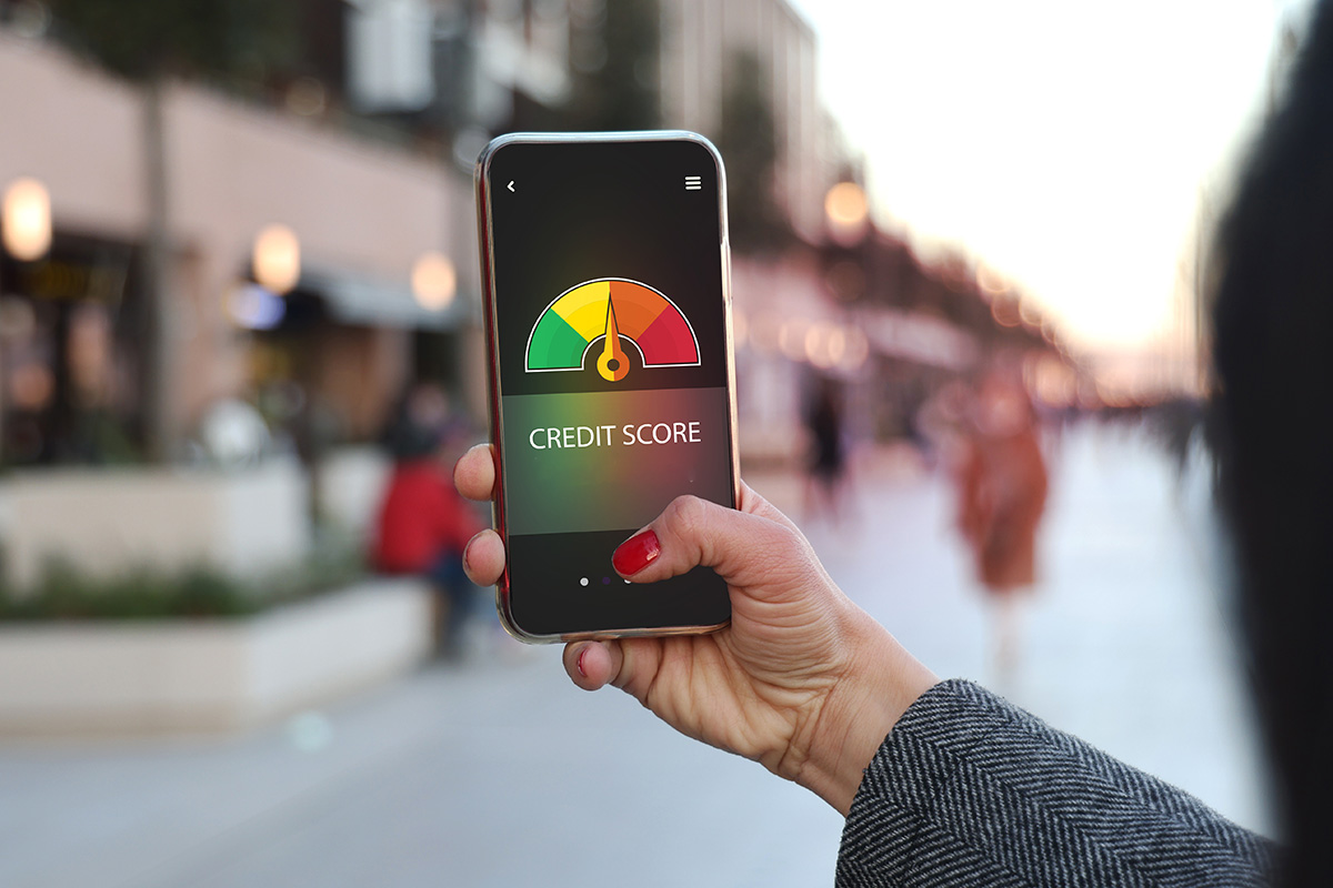 A woman's hand using a mobile phone to check credit score