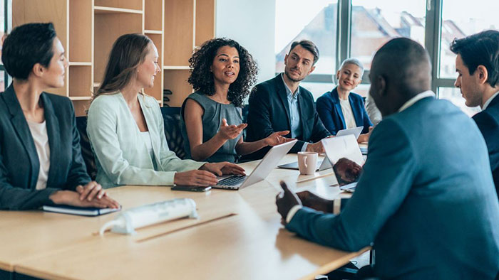 Seven professionals in a board meeting