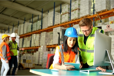 Two people looking at a tablet in a warehouse