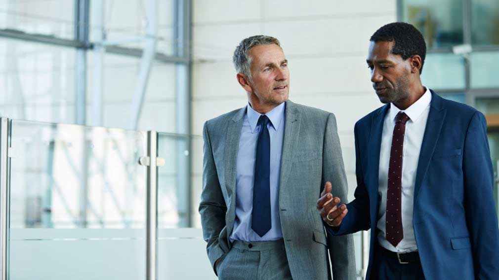 Two businessmen walking and talking