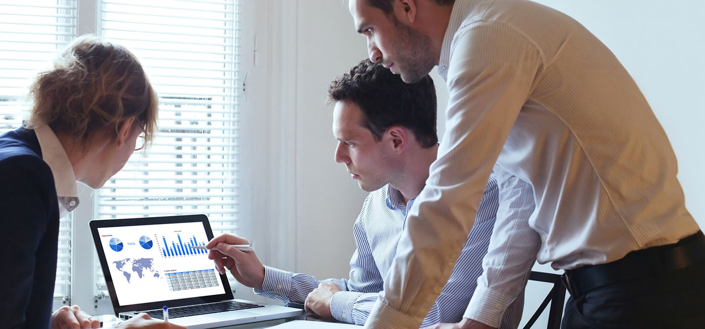 people in an office looking at a laptop