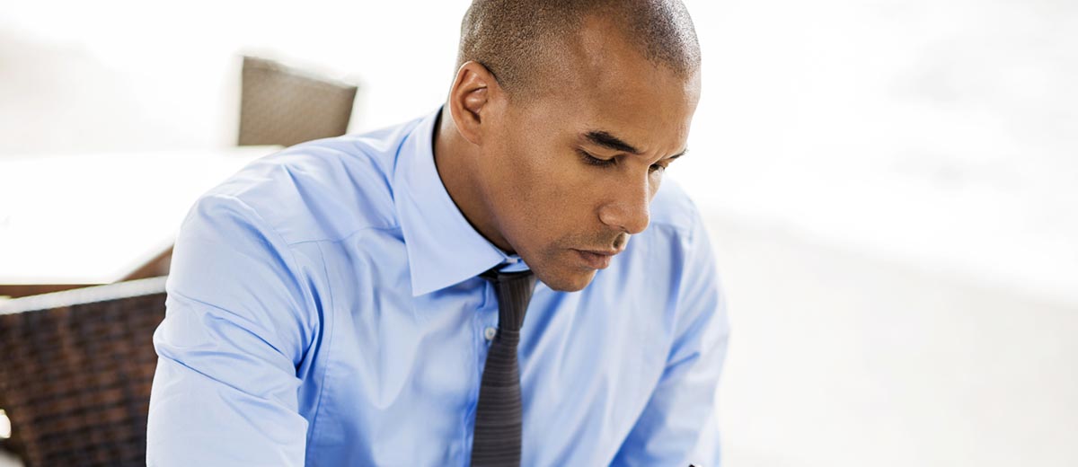 Office man looking down at device looking up what is the kyc rule and why it is important.