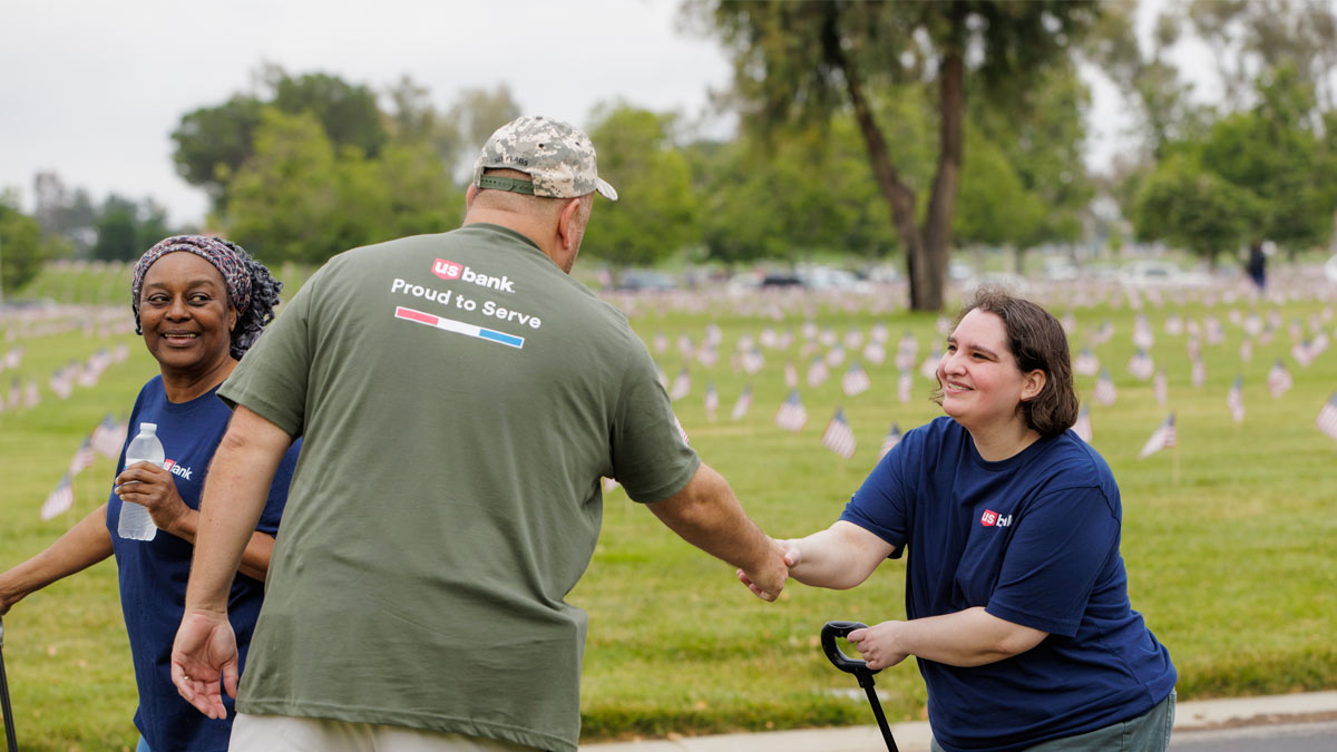 People at a veterans cemetary placing flags