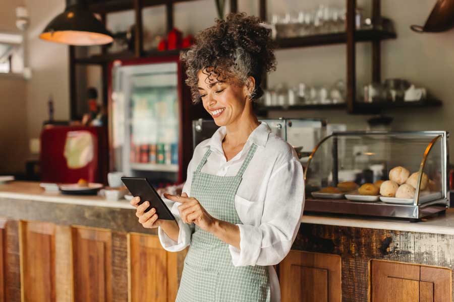 Owner of a coffee shop researching business CD accounts on her tablet.