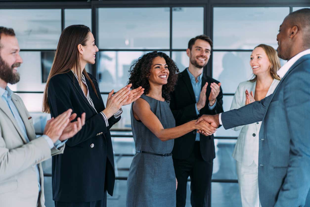 Image of colleagues clapping and congratulating women