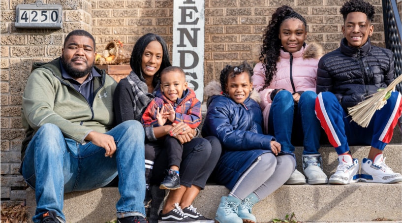 The Dismukes family of six is pictured smiling for a portrait who moved into their new home in 2020 after working with Acts Housing.